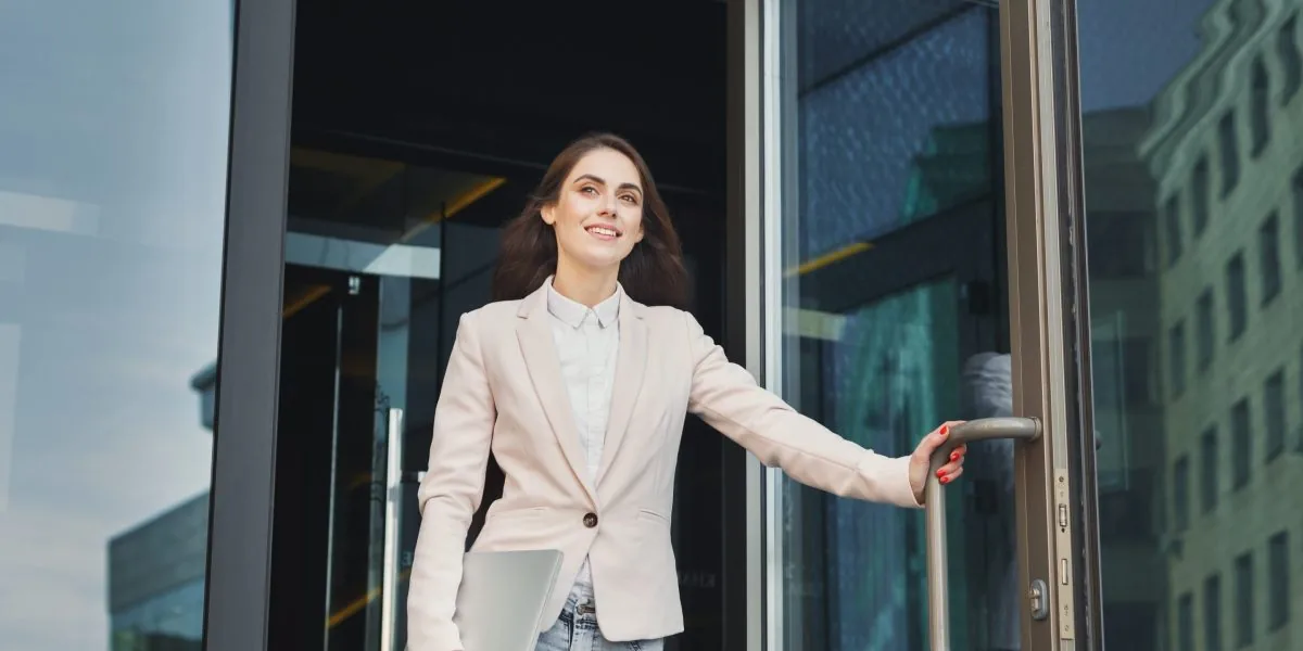 A worker leaving an office early while a CEO watches the time