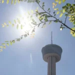 Downtown San Antonio skyline under bright summer heat and scattered clouds